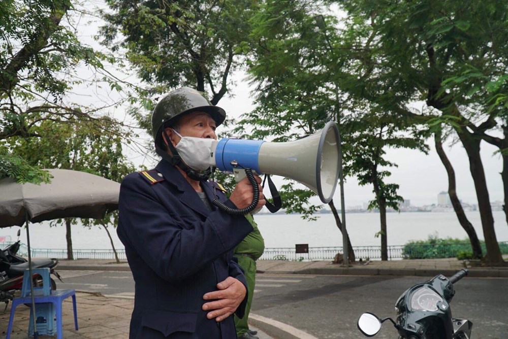 Lực lượng bảo vệ tại Hồ Hoàn Kiếm (HN) gọi loa yêu cầu mọi người đi tập thể dục về nhà để phòng chống lây lan dịch Covid-19
