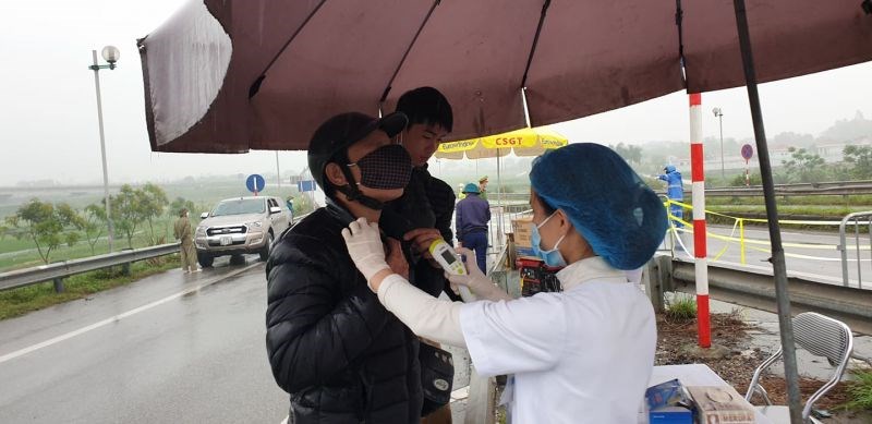 Cán bộ y tế tiến hành đo thân nhiệt cho các tài xế tại chốt số 10, quốc lộ 18 lối xuống đường Võ Văn kiệt để vào HN
