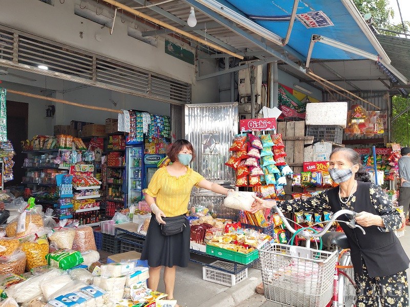 Chủ cửa hàng và người dân tham gia thực hiện giữ khoảng cách an toàn khi mua sắm tại khu vực chợ dân sinh trên địa bàn xã Yên Viên, huyện Gia Lâm