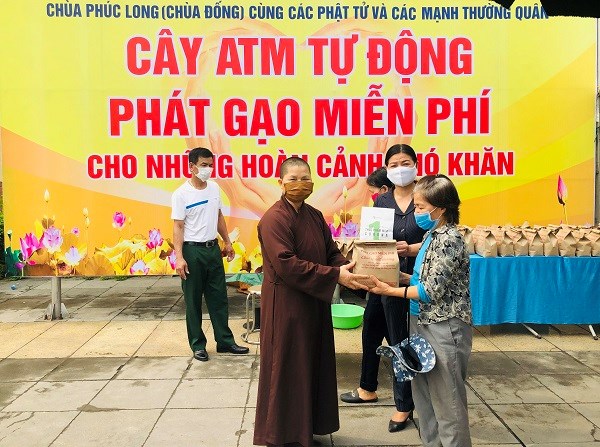 Thầy Thích Đàm Hoài, trụ trì chùa Phúc Long cùng Phó Chủ tịch MTTQ huyện Thanh Trì Nguyễn Thị Thắm trao phát gạo miễn phí cho người dân khó khăn