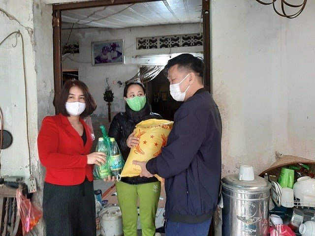 Chị Nguyễn Thị Lệ Hằng - Chủ tịch Hội LHPN Quận Hoàng Mai (áo đỏ) trao quà cho gia đình hội viên có hoàn cảnh khó khăn.