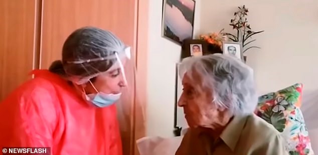 Bà Maria Branyas trò chuyện cùng một người chăm sóc trong bộ đồ bảo hộ