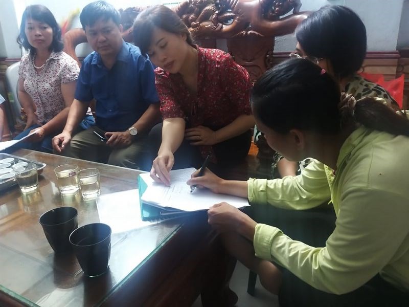 Chị Đào Thị Lợi ký vào biên bản nhận lại con do chính quyền trao trả