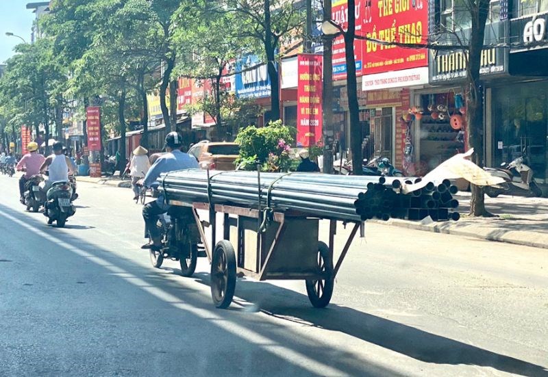 Xe máy cũ ngang nhiên chở hàng cồng kềnh lưu thông trên đường phố của Hà Nội.