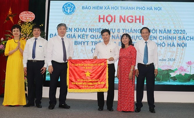 Phó Chủ tịch UBND TP Hà Nội Ngô Văn Quý trao Cờ thi đua đơn vị xuất sắc phong trào thi đua của UBND TP tới lãnh đạo Bảo hiểm xã hội thành phố