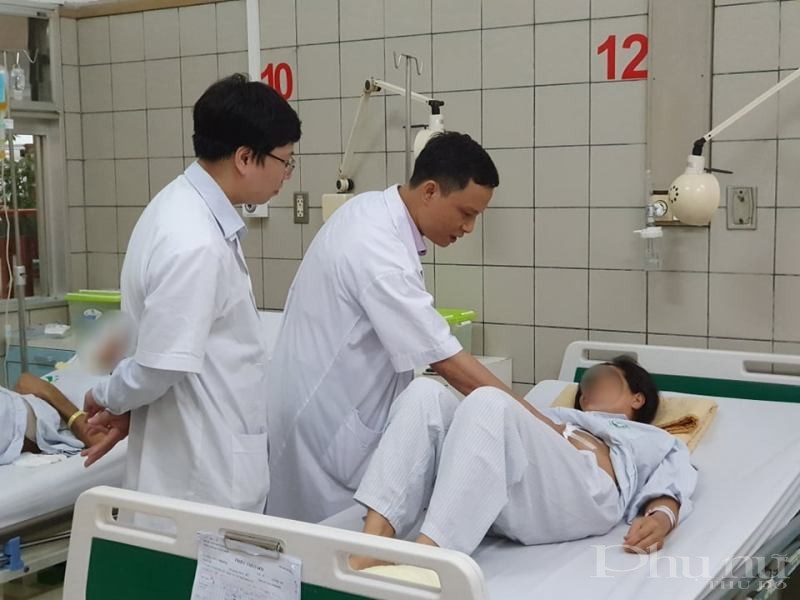 TS.BS Trần Mạnh Hùng và BS. Trần Quế Sơn thăm khám cho bệnh nhân trước khi xuất viện.