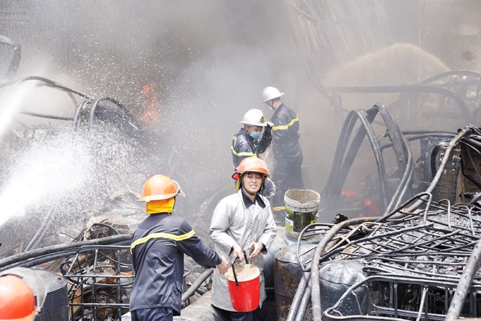 Lính cứu hỏa vật lộn trong đám cháy xử lý cháy lan. (Ảnh: Đạt Lê)