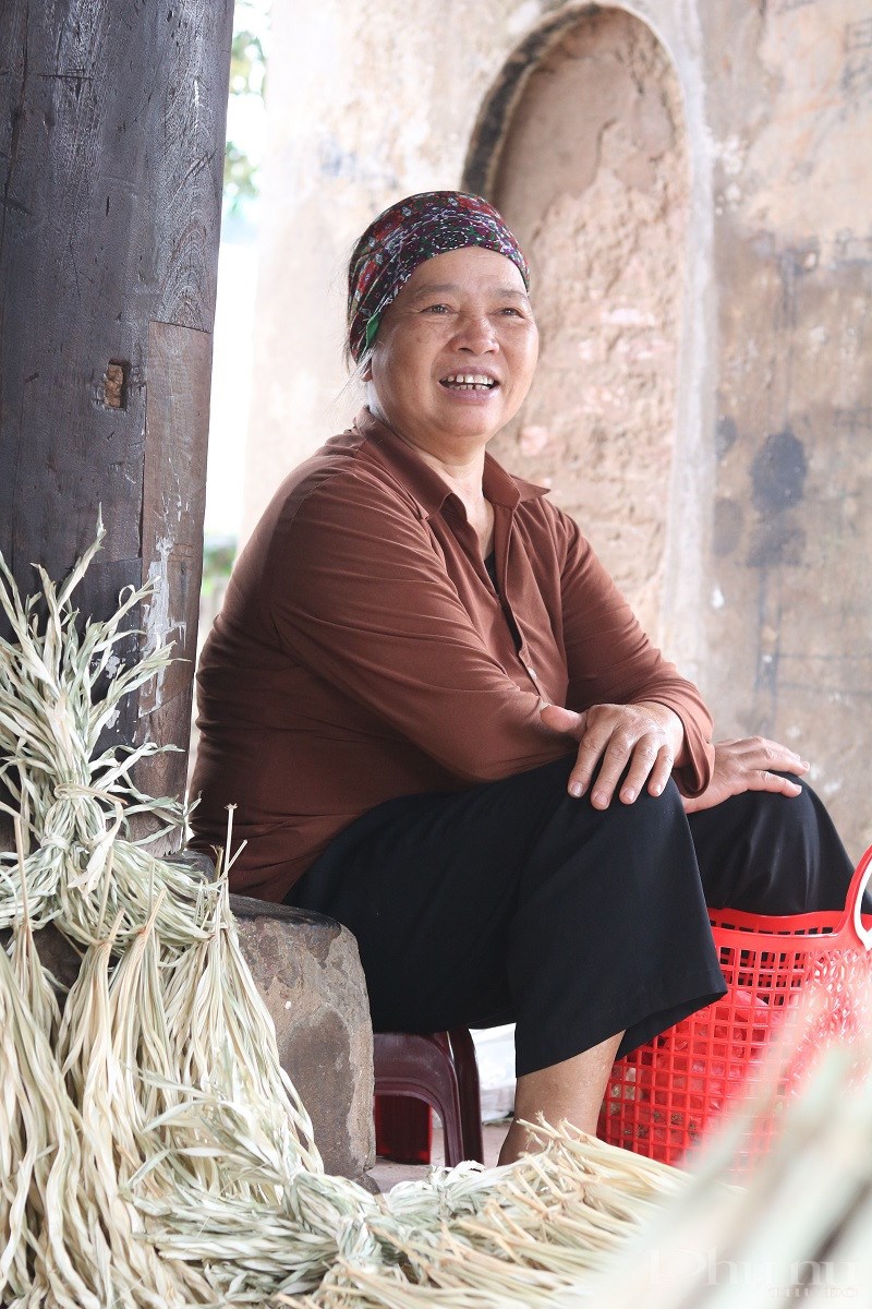 Nụ cười hồn hậu, lạc quan của bà Hoàng Thị Tuyết - gần 40 năm bán nón tại đình làng Chuông. Ảnh: Minh Hiền