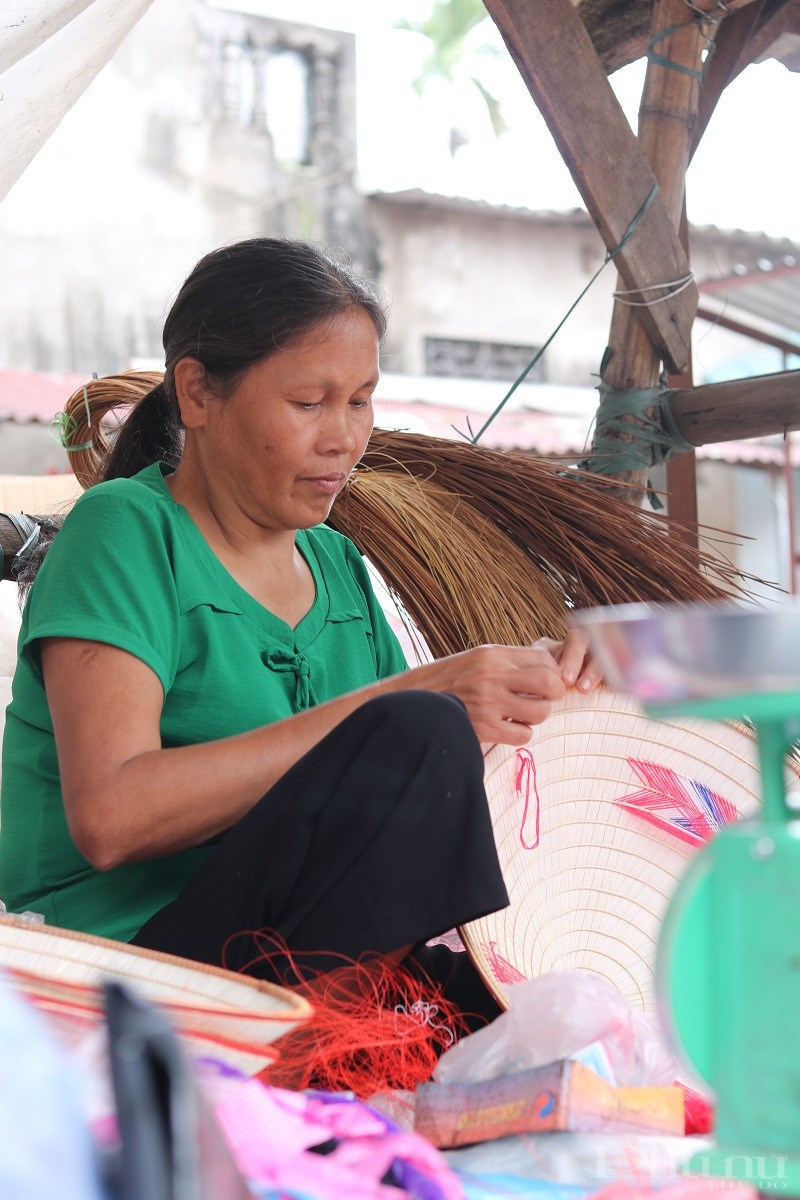 Ảnh 2: Đôi bàn tay khéo léo đan nón của một tiểu thương tại đình làng Chuông. Ảnh: Minh Hiền