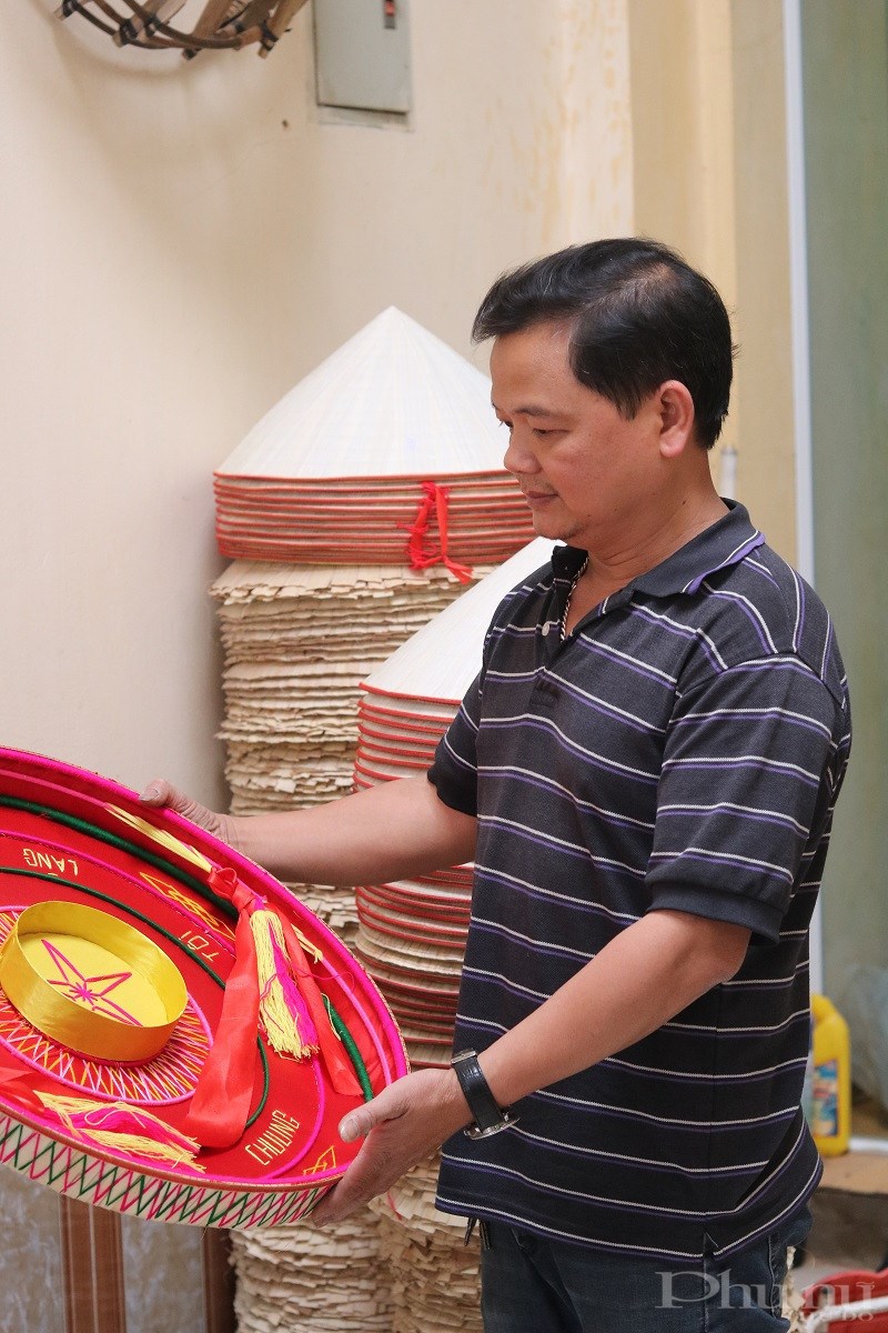 Nghệ nhân Nguyễn Văn Tuy nâng niu chiếc nón quai thao được cách điệu. Ảnh: Minh Hiền