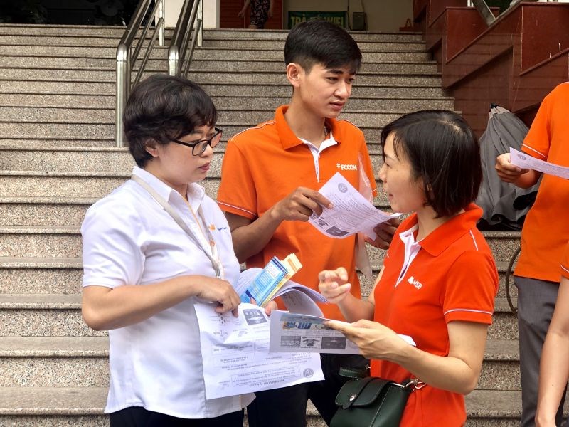 Cán bộ Bảo hiểm xã hội và Bưu điện Hà Nội tuyên truyền tới người dân về chính sách bảo hiểm xã hội tự nguyện và bảo hiểm y tế hộ gia đình