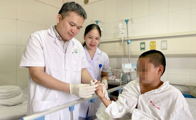 Bác sĩ của Bệnh viện Hữu nghị Việt - Đức kiểm tra ngón tay của bệnh nhi 11 tuổi (ở tỉnh Bắc Ninh) sau khi được nối lại.
