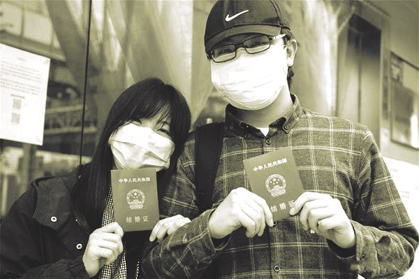 Anh Lu và vợ, cô Đinh khoe giấy chứng nhận kết hôn tại văn phòng đăng ký kết hôn ở Vũ Hán