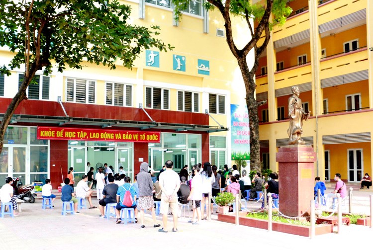 Tại điểm test nhanh Trường THCS Nguyễn Trãi, quận Ba Đình, Hà Nội, có khoảng 100 người đến xét nghiệm nhanh.