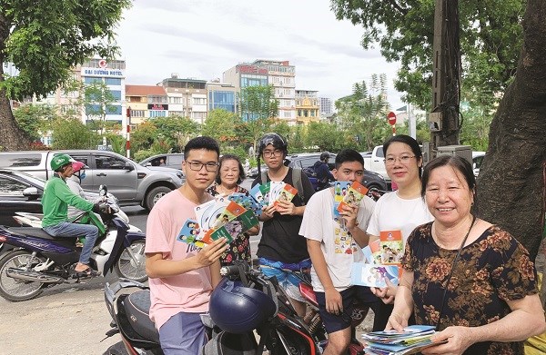 Các em học sinh tại phường Láng Thượng được phát tờ rơi tuyên tuyền nhằm hưởng ứng Ngày Dân số thế giới 11/7