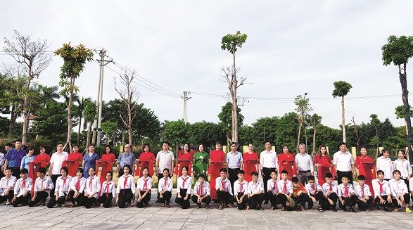 Các đồng chí lãnh đạo Hội LHPN Hà Nội, huyện Đông Anh cắt băng khánh thành, chụp ảnh cùng các em học sinh tại lê bàn giao sân chơi cộng đồng tại thôn Thượng Phúc xã Bắc Hồng