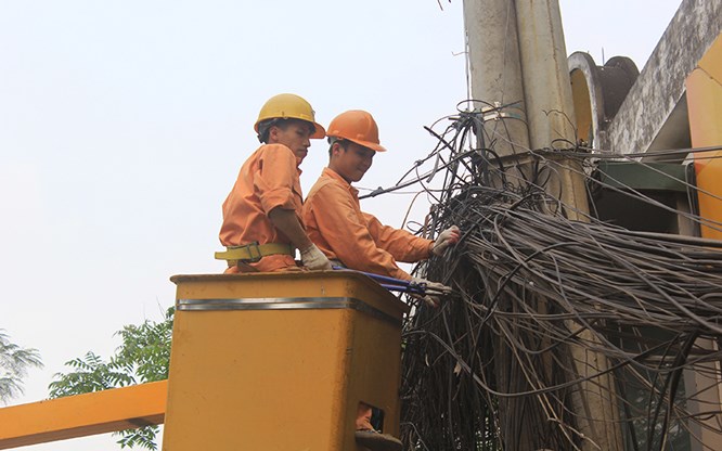 Công nhân EVN Hà Nội thanh thải đường dây điện tại phố Đội Cấn (quận Ba Đình), ảnh chụp năm 2019. Ảnh: Đỗ Tâm