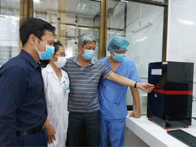 Thứ trưởng Bộ Y tế Nguyễn Trường Sơn và các chuyên gia kiểm tra hệ thống thiết bị xét nghiệm trong ngày đầu khai trương.