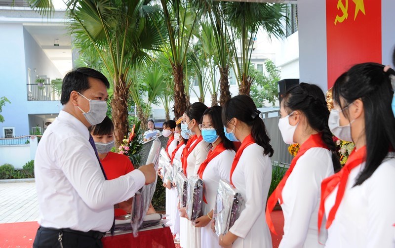 Nữ sinh  lớp 9, trường THCS Kim Giang mặc áo dài, được lãnh đạo quận Thanh Xuân tặng cặp sách