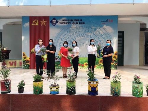Đồng chí Nguyễn Lan Hương – Chủ tịch Hội LHPN quận Đống Đa (ngoài cùng bên trái) tặng các chậu hoa tái chế từ bếp than tổ ong cho trường tiểu học La Thành ảnh HPN