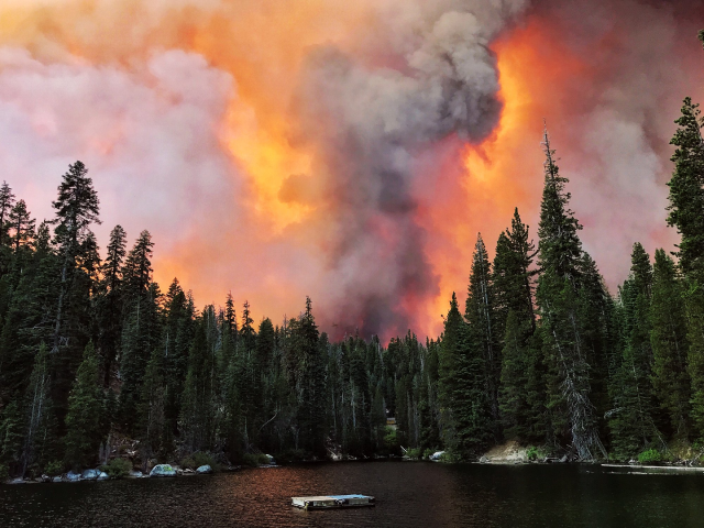 Khói từ đám cháy cuồn cuộn vượt qua một sườn núi và được nhìn thấy từ Hồ Huntington