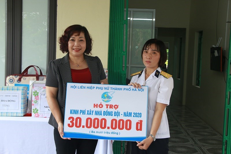 Đồng chí Lê Thị Thiên Hương, Phó Chủ tịch Hội LHPN Hà Nội trao biển tượng trưng kinh phí hỗ trợ xây nhà cho trung úy Bùi Thị Hiền.