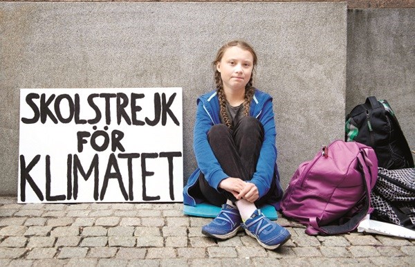 Greta Thunberg bên cạnh tấm biển với nội dung “Bãi khóa vì khí hậu”.
