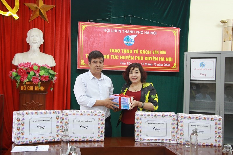 Đồng chí Trần Văn Khiêm, Phó Bí thư, Chủ tịch UBND xã Phú Túc tiếp nhận sách từ Hội LHPN Hà Nội