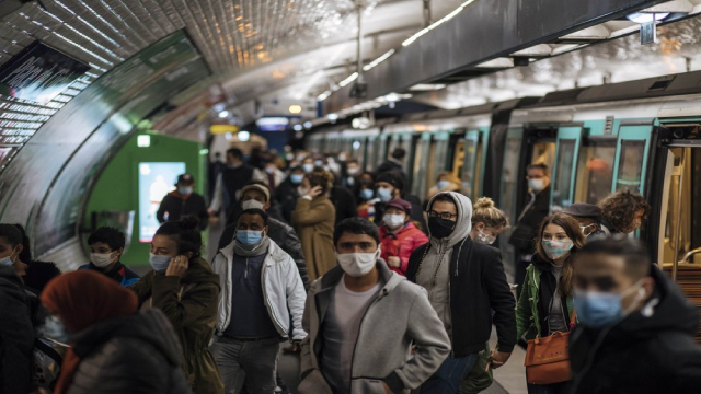 Người dân đeo khẩu trang đi bộ trên sân ga tàu điện ngầm Paris.