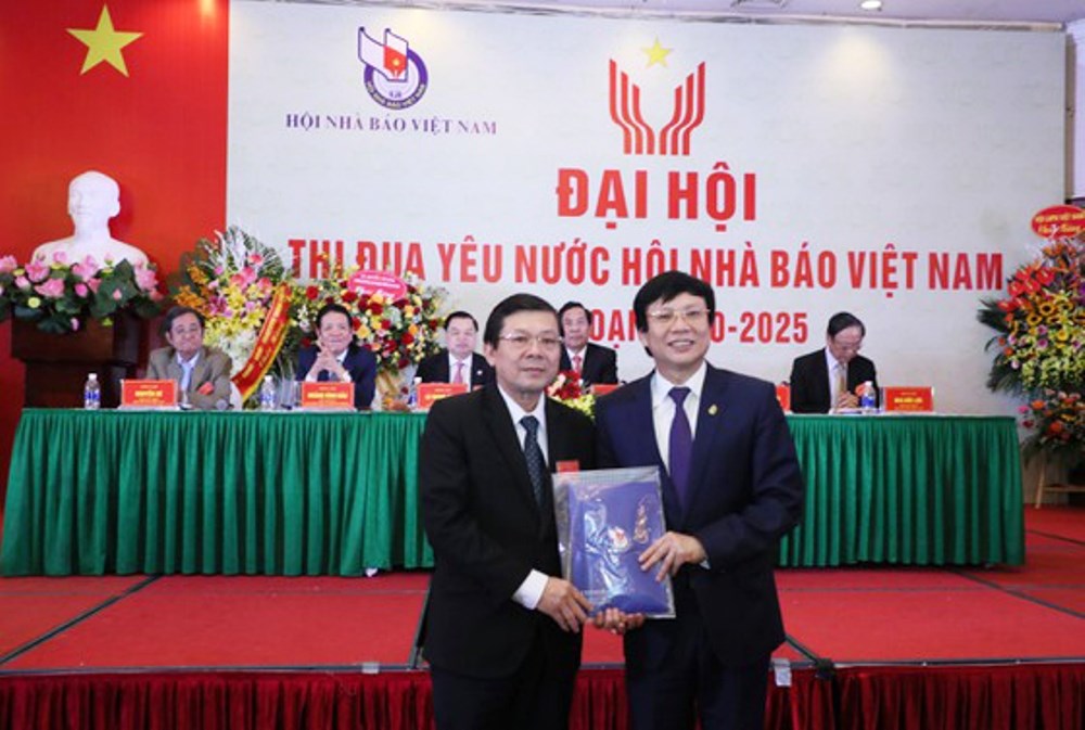 Phó Chủ tịch Thường trực Hội Nhà báo Việt Nam Hồ Quang Lợi trao số tiền quyên góp của đại hội ủng hộ đồng bào miền Trung bị ảnh hưởng bởi lũ lụt cho đại diện Mặt trận Tổ quốc Việt Nam.