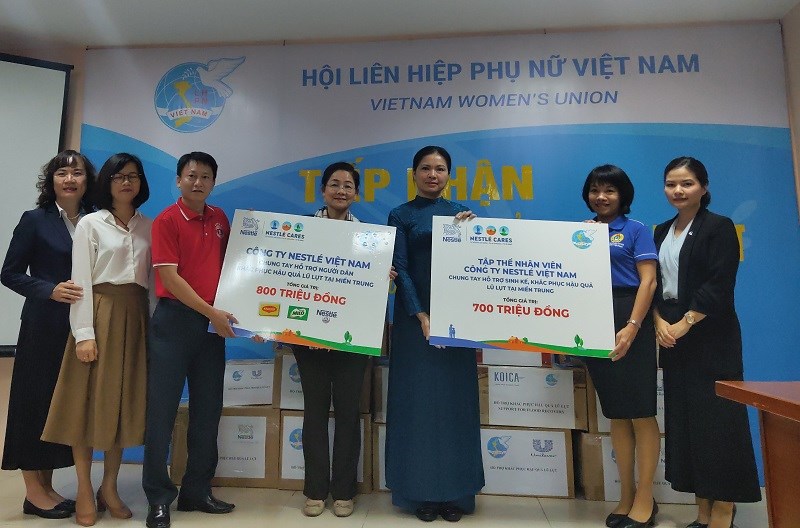 Đồng chí  Hà Thị Nga - Chủ tịch Hội LHPN Việt nam ( ở giữa áo dài xanh), Phó Chủ tịch Hội Trần Thị Hương (kế bên trái) nhận ủng hộ từ công ty Nestle