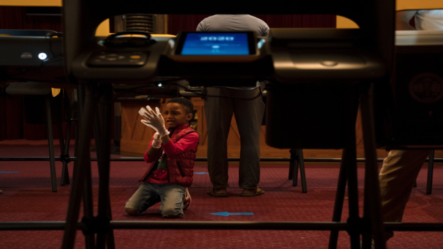 King Henry, 6 tuổi, chơi đùa với găng tay bảo hộ của mình trong khi chờ bà ngoại kết thúc cuộc bỏ phiếu tại Nhà hát Hollywood Pantages, Los Angeles. (Ảnh AP / Jae C. Hong).
