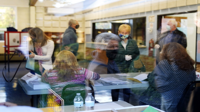 Một người phụ nữ được phản chiếu qua cửa sổ bên ngoài một điểm bỏ phiếu cho cuộc tổng tuyển cử năm 2020 ở Hoa Kỳ tại Springfield, Pa. (Ảnh AP / Matt Slocum).