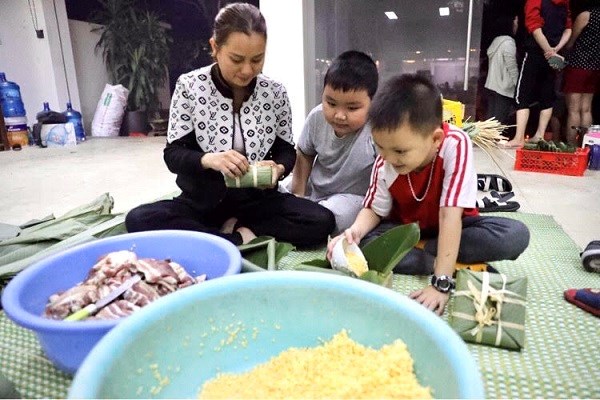 Mẹ con chị Nguyễn Thị Thu Hiền cùng tham gia gói bánh chưng để gửi vào miền Trung