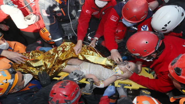 Bé Ayda Gezgin được quấn trong một chiếc chăn giữ nhiệt và đưa vào xe cấp cứu trong tiếng reo hò và vỗ tay từ các nhân viên cứu hộ.