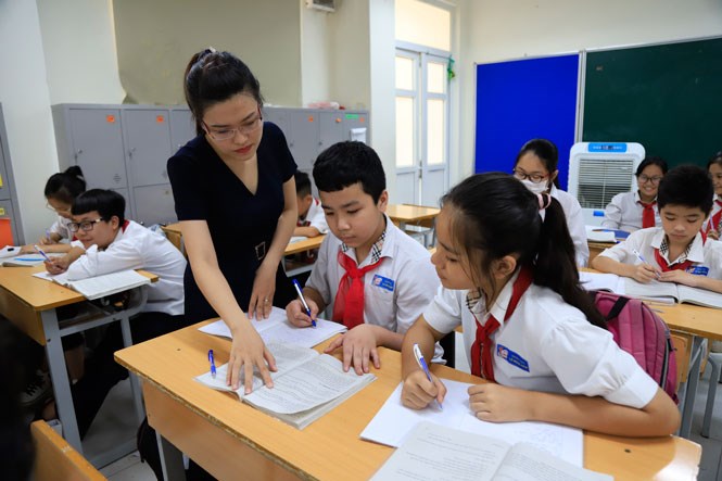 Giáo viên hướng dẫn học sinh làm bài tại Trường Trung học cơ sở Lê Ngọc Hân (quận Hai Bà Trưng). Ảnh: Nguyễn Quang