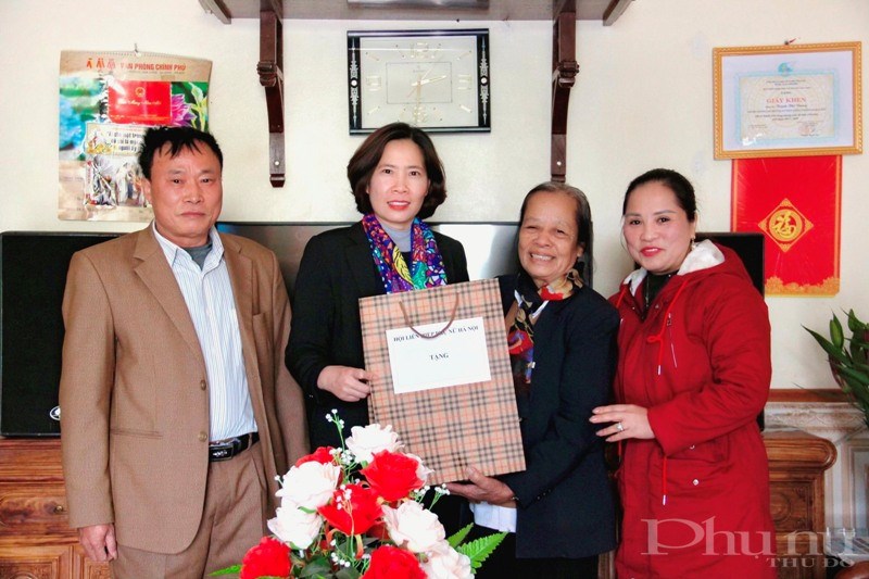Chủ tịch Hội LHPN Hà Nội Lê Kim Anh (thứ 2 từ trái sang) tặng quà bà Trịnh Thị Dung
