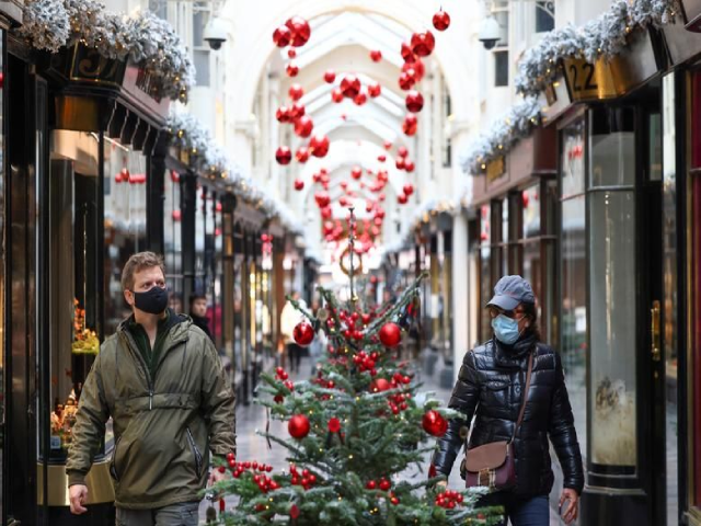 Đại dịch COVID-19 khiến trung tâm mua sắm Burlington Arcade tại London, Anh vốn dĩ nhộn nhịp trở nên ảm đạm hơn bao giờ hết. Trong ảnh, người dân đi bộ qua Burlington Arcade được trang trí với những cây thông Noel.