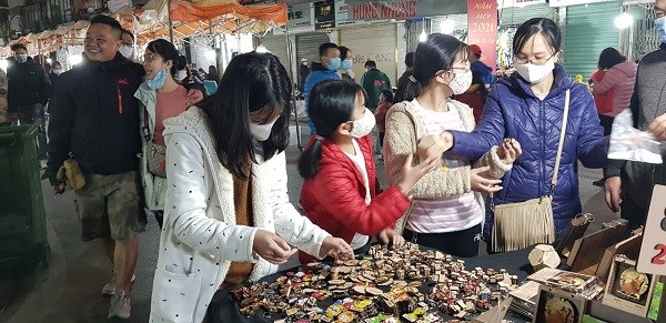 Các bạn trẻ hào hứng chọn hàng handmade làm từ gỗ ở phố Hàng Đào, Hà Nội