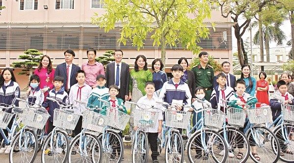 Các em học sinh nhận quà tặng của Hội PN là những chiếc xe đạp nhằmnâng bước chân em tới trường