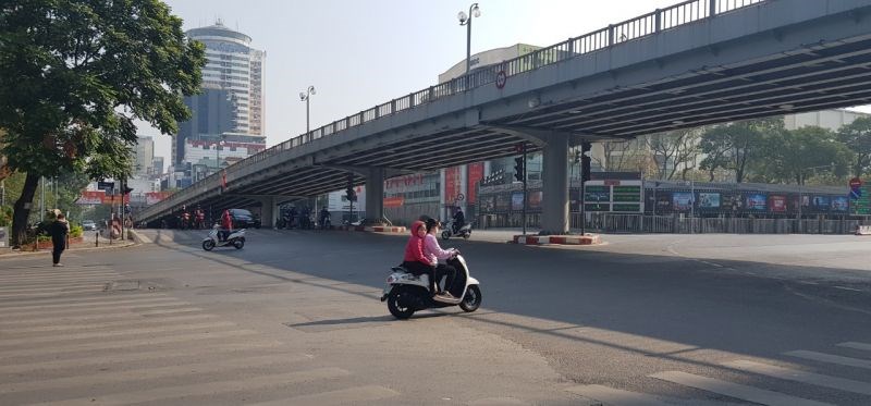 Mẹ chở con trên xe mô tô vừa không đội mũ bảo hiểm vừa vượt đèn đỏ tại ngã tư Huỳnh Thúc Kháng - Láng Hạ