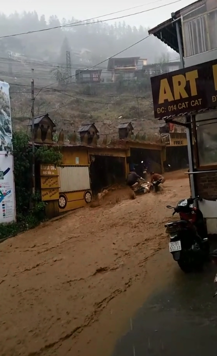 Hình ảnh dòng nước lũ chảy xiết, cuốn theo cả chiếc xe máy của người dân khiến nhiều người sợ hãi