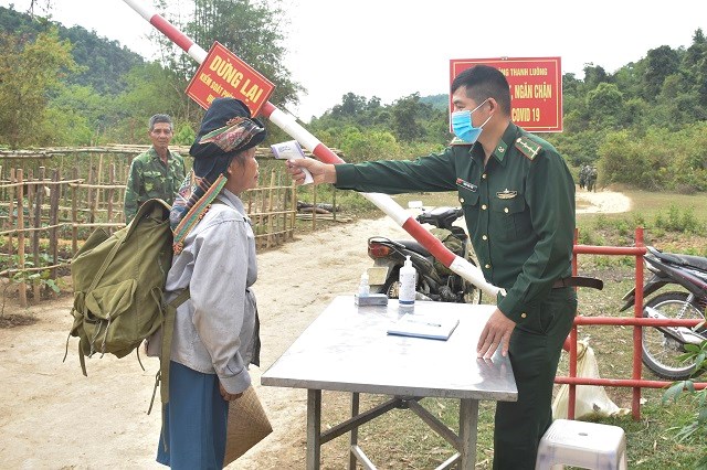 Chiến sỹ trực chốt kiểm soát dịch Lếch Cuông, Đồn BP Thanh Luông đo thân nhiệt cho người dân khi đi qua chốt