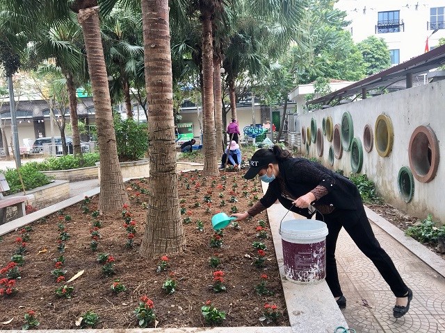 Chị em hội viên phụ nữ xã Ninh Hiệp trồng và chăm sóc hoa tại khu vực sân chơi Nhà văn hóa thôn 9