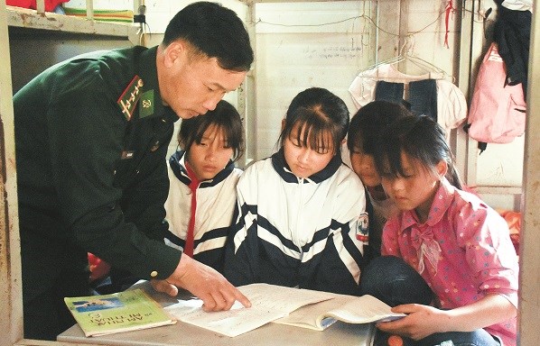 Thượng úy Lìu Láo Lanh kèm các em nhỏ học bài