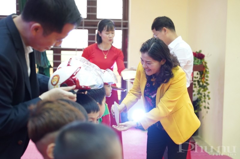 Thứ trưởng Bộ LĐ-TB&XH (áo vàng) cùng các đại biểu và đại diện từ Generali Việt Nam trao tặng quà và hỗ trợ tài chính cho các trẻ em có hoàn cảnh khó khăn tại địa phương.