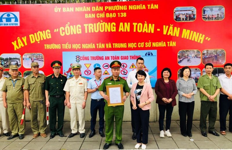Phó Chủ tịch UBND quận Trịnh Thị Dung, Trưởng Ban chỉ đạo 138 trao quyết định xây dựng triển khai mô hình Cổng trường an toàn văn minh cho phường Nghĩa Tân