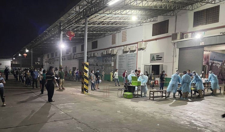 Nhân viên y tế thực hiện lấy mẫu xét nghiệm cho các công nhân tại Nhà máy sản xuất vải Din Han, thành phố Stung Meanchey, Campuchia.