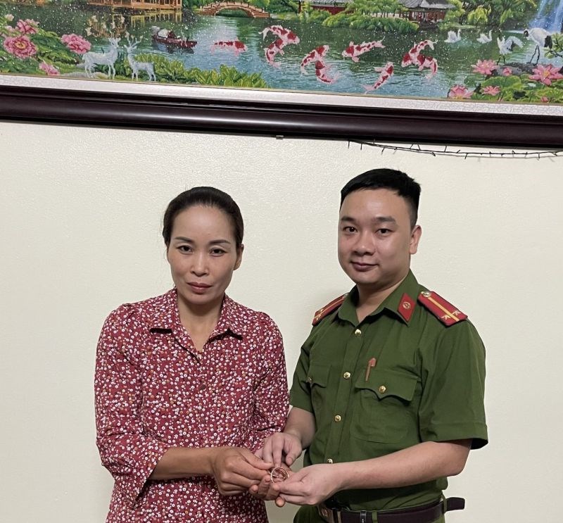 Trung úy Nguyễn Đức Thuận trao vàng nhặt được cho chủ nhân là chị Trương Thị Thắm