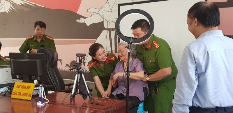Cán bộ công an quận Hà Đông hỗ trợ người dân người dân chụp ảnh thẻ